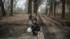 UKRAINE -- An elderly man smokes a cigarette as he waits to fill up gallons of water, in Chasiv Yar, in the region of Donbas, on March 16, 202