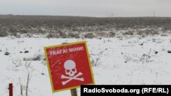 Участкі, якія абясшкоджваюць ад мін, агароджваюць пафарбаванымі ў чырвоны колер палкамі і пазначаюць таблічкамі. Бучанскі раён, лістапад 2022 году. Архіўнае фота