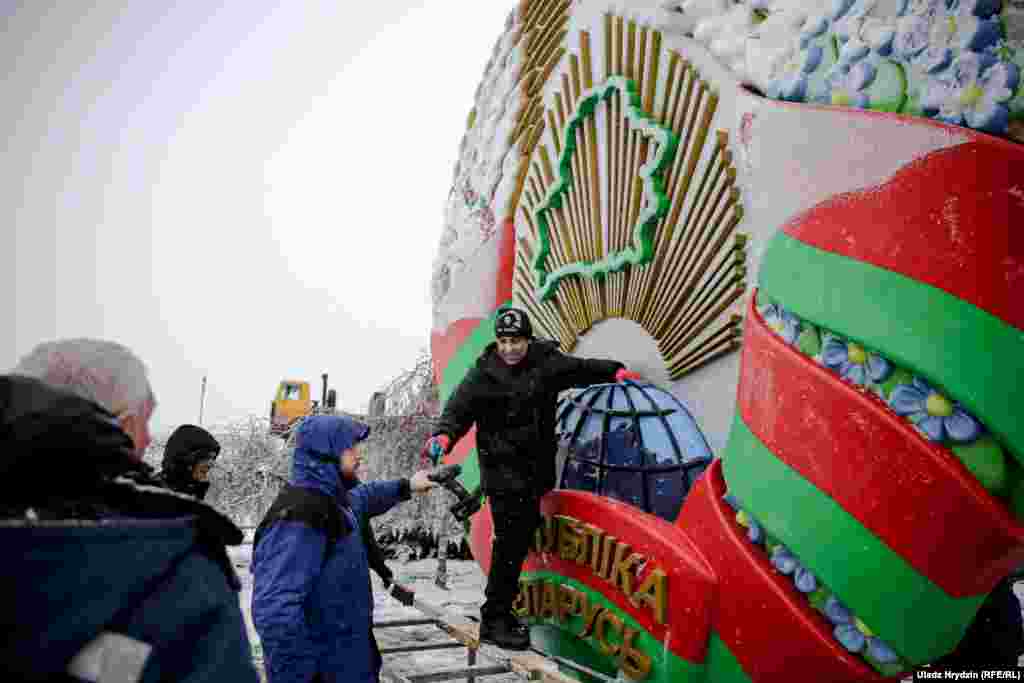 Рабочыя мацуюць дзяржаўны герб побач з Нацыянальным аэрапортам, 29 студзеня&nbsp; &nbsp;