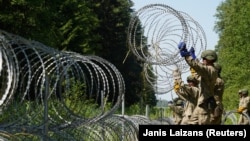 Літоўскія вайскоўцы будуюць агароджу на мяжы зь Беларусьсю ў ліпені 2021 году