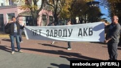 Аляксей Пятрухін і Аляксандар Кабанаў трымаюць лёзунг падчас адной з акцыі пратэсту супраць будаўніцтва акумулятарнага заводу каля Берасьця