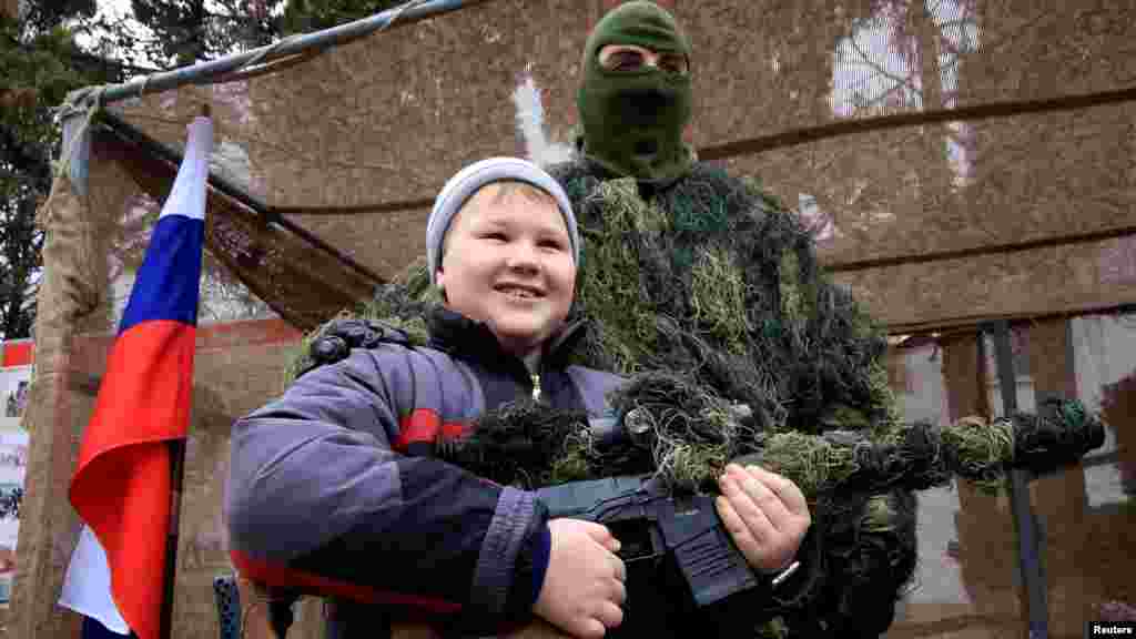 Ребенок с оружием во время празднования Дня морской пехоты в порту Черного моря в Севастополе